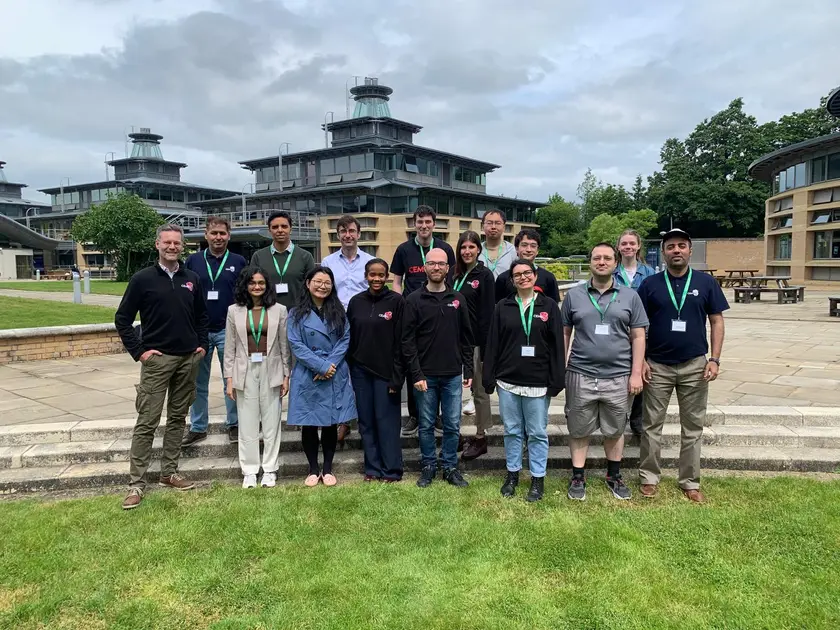 The group standing on a lawn in front of a conference centre