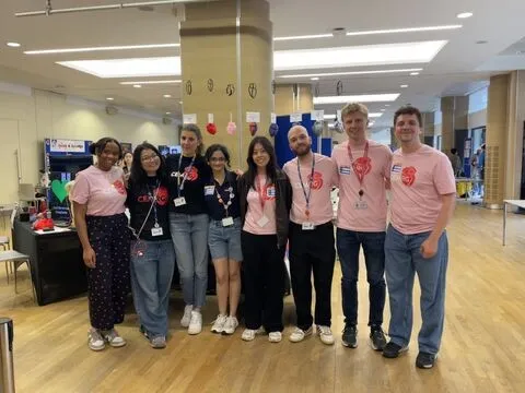 Members of the group in their festival T-shirts at the stand in the Queen's Tower Rooms